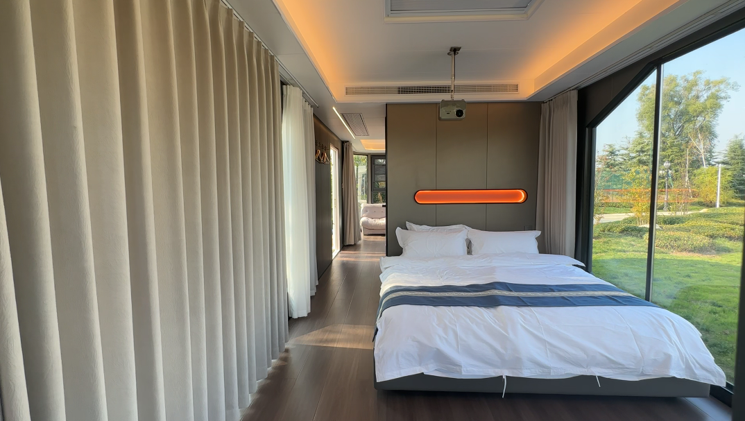 Interior of the bahria homes House D7 featuring a modern bedroom with large floor-to-ceiling windows, warm lighting, and elegant minimalist design overlooking a scenic outdoor view.